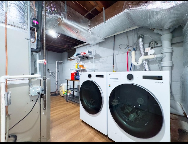 laundry room featuring washing machine and clothes dryer and light wood-type flooring