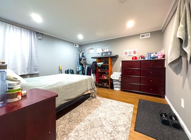 bedroom with light hardwood / wood-style flooring and ornamental molding