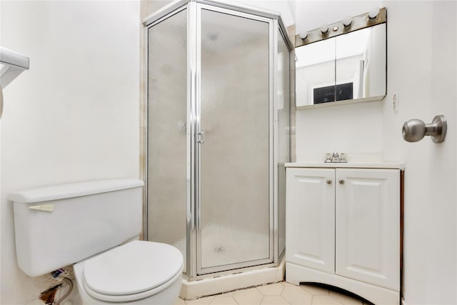 bathroom featuring tile patterned flooring, vanity, toilet, and a shower with door