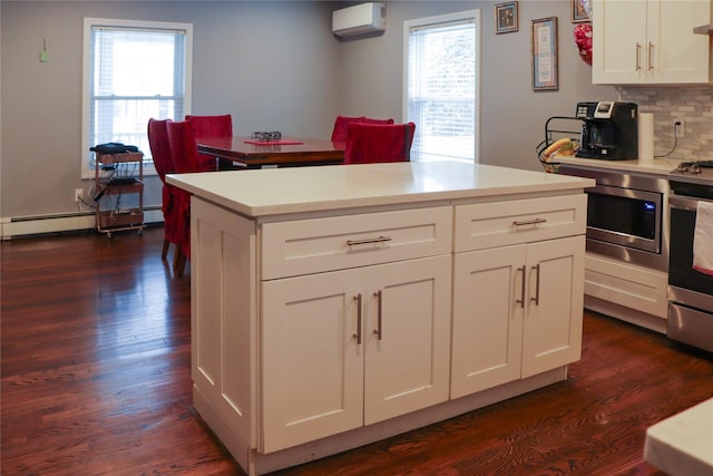 29 Oak St, Islip, NY 11751 - kitchen featuring stainless steel appliances, an AC wall unit, dark wood finished floors, and light countertops