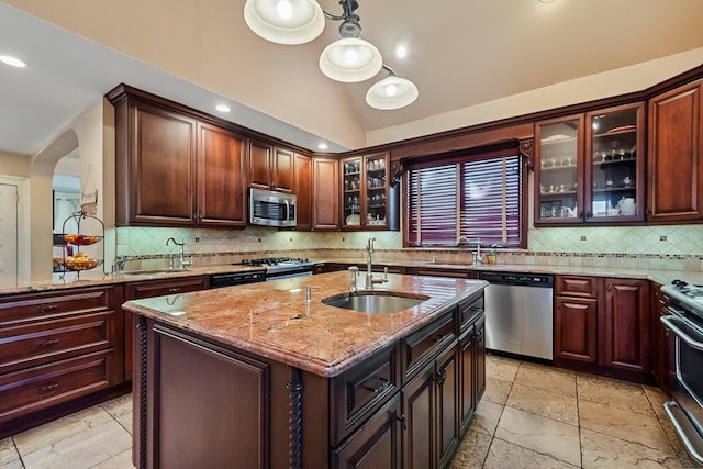 kitchen with a center island with sink, sink, lofted ceiling, and stainless steel appliances