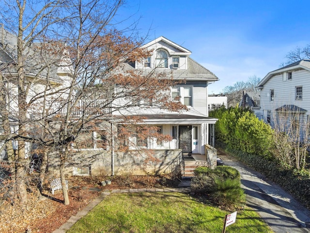 view of front of property featuring covered porch and a front lawn