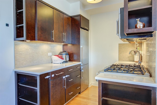 kitchen with backsplash, light hardwood / wood-style floors, stainless steel refrigerator, and dark brown cabinetry