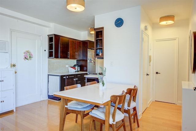 kitchen featuring dark brown cabinetry, tasteful backsplash, and light hardwood / wood-style floors