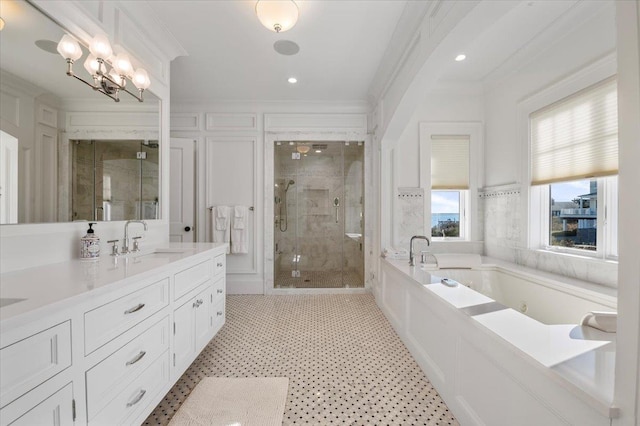 bathroom with plus walk in shower, vanity, an inviting chandelier, and crown molding