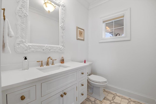 bathroom with vanity, toilet, and ornamental molding