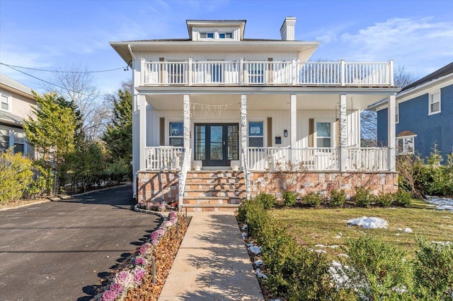 view of front of property featuring a porch and a balcony