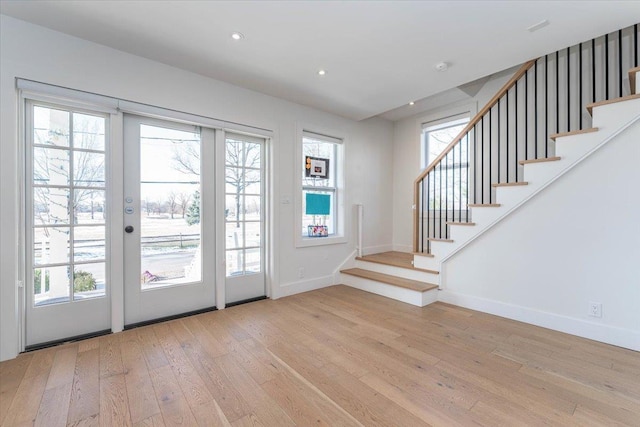 entryway featuring light wood-type flooring, a wealth of natural light, and french doors