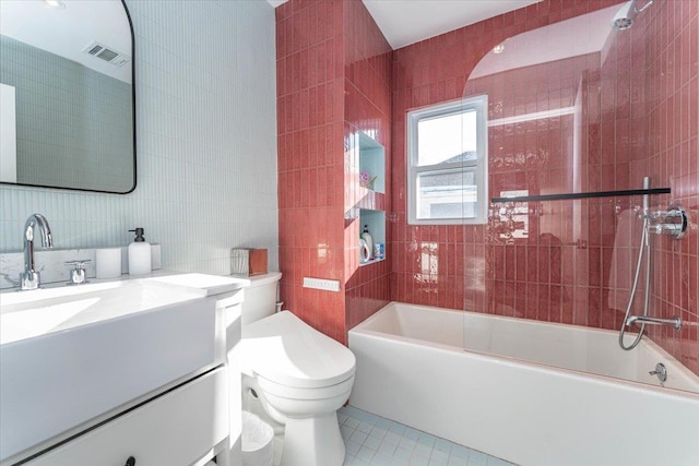 full bathroom with vanity, shower / tub combination, tile walls, tile patterned flooring, and toilet