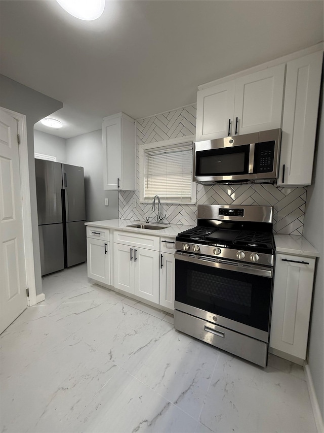 kitchen featuring tasteful backsplash, sink, stainless steel appliances, and white cabinets