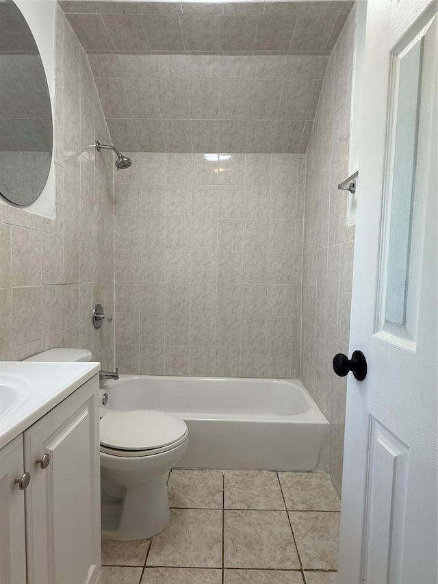 full bathroom with tiled shower / bath combo, vanity, tile patterned floors, and toilet