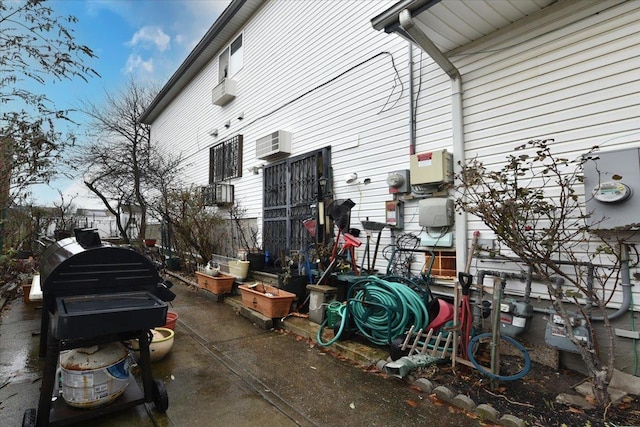 view of side of home featuring a wall mounted air conditioner and a patio