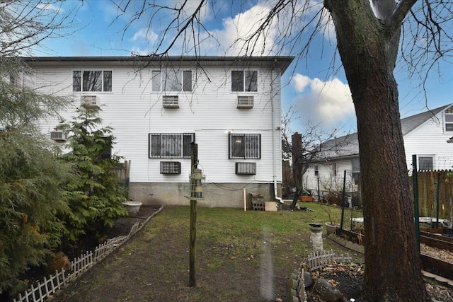 rear view of property featuring a lawn