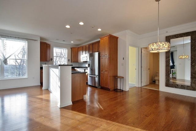 kitchen with pendant lighting, light hardwood / wood-style floors, stainless steel fridge with ice dispenser, and ornamental molding