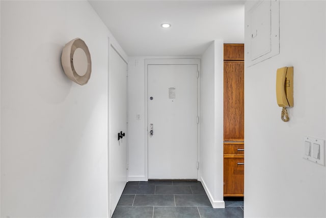 doorway to outside with dark tile patterned flooring