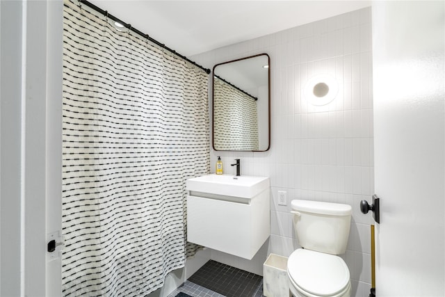 bathroom featuring vanity, toilet, curtained shower, and tile walls