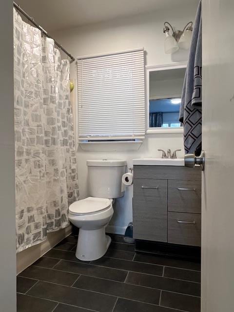 bathroom with vanity, curtained shower, and toilet