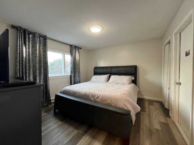 bedroom featuring a baseboard radiator and dark hardwood / wood-style floors