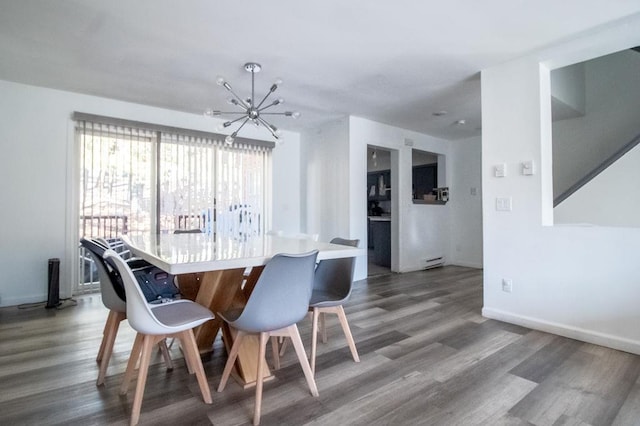 dining space featuring a notable chandelier, dark wood-type flooring, and a baseboard radiator