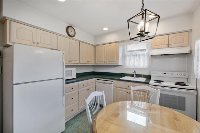 kitchen featuring white appliances, sink, hanging light fixtures, and a chandelier