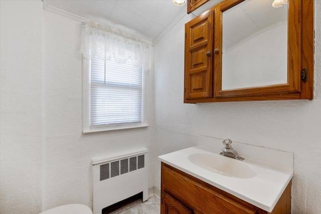 bathroom with vanity, radiator heating unit, and ornamental molding