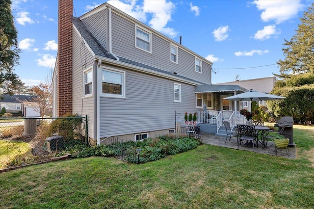 rear view of property with a yard and a patio area