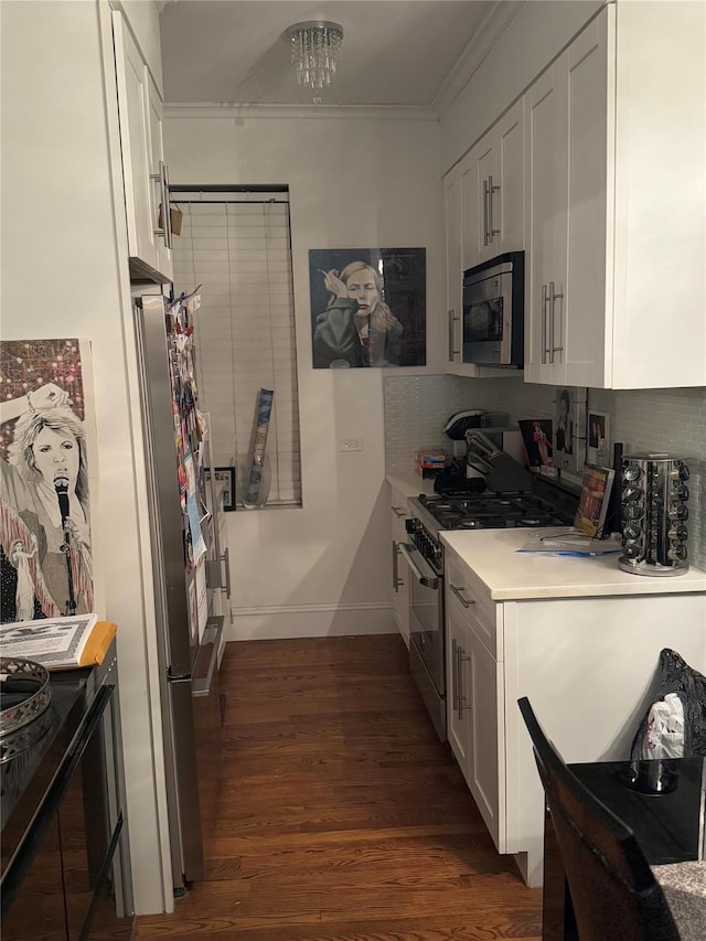 kitchen with tasteful backsplash, white cabinets, stainless steel appliances, and dark hardwood / wood-style floors