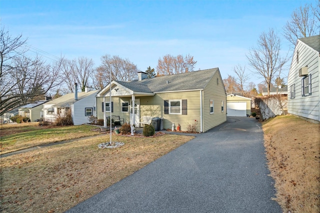 view of front facade with a front yard, a garage, an outbuilding, and central air condition unit