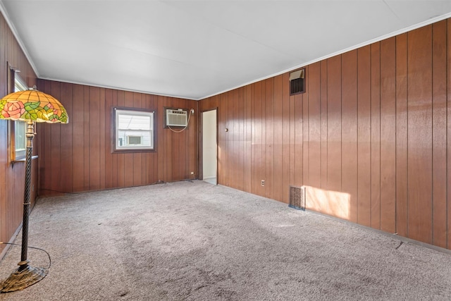 carpeted empty room featuring ornamental molding, a wall mounted air conditioner, and wooden walls