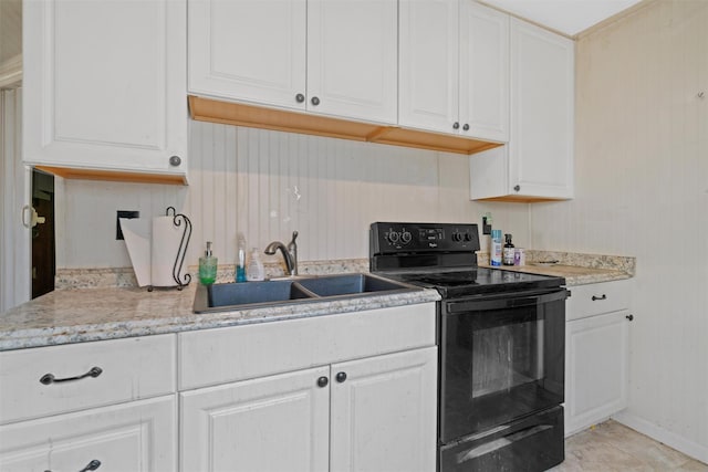 kitchen with white cabinets, black electric range, and sink