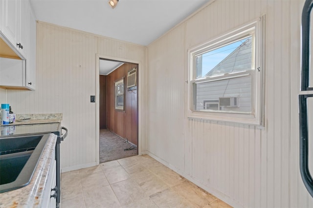 kitchen featuring wood walls and light tile patterned floors