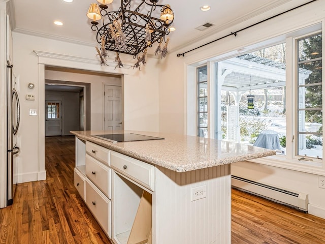 kitchen with stainless steel fridge, white cabinetry, a baseboard heating unit, a center island, and black electric cooktop