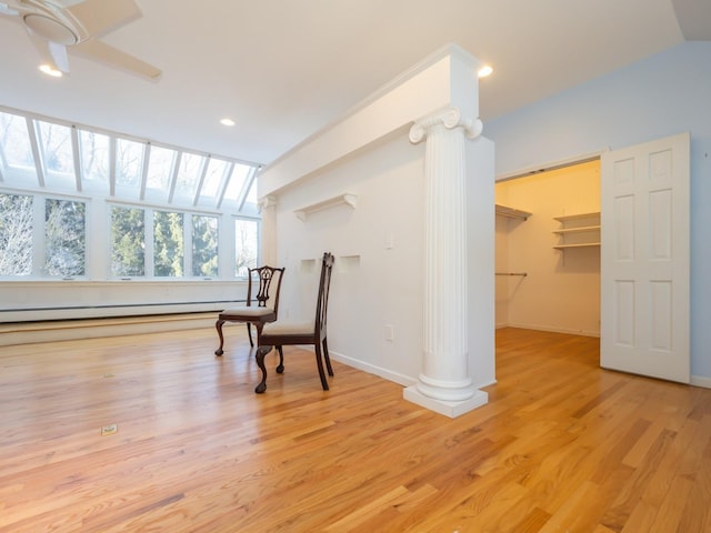 sitting room with ornate columns, vaulted ceiling, a baseboard heating unit, and light wood-type flooring