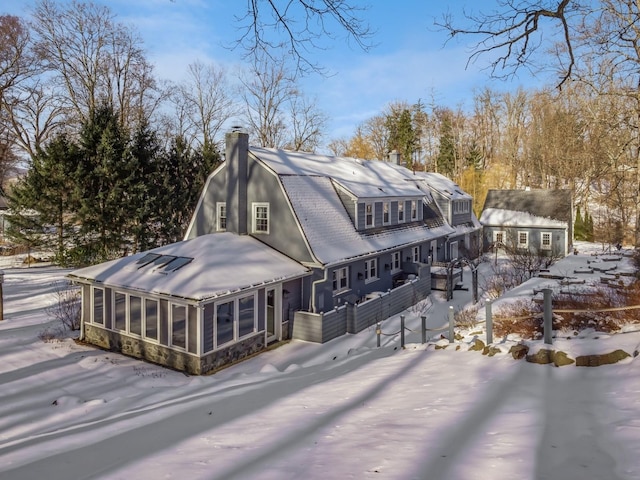 snow covered house with a sunroom