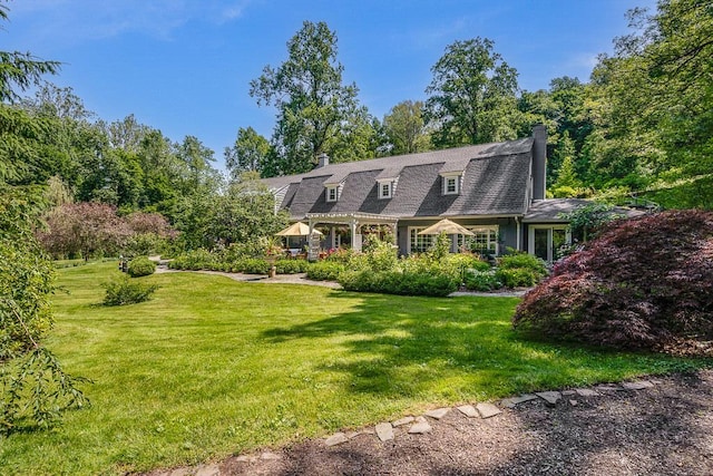 cape cod home featuring a front lawn