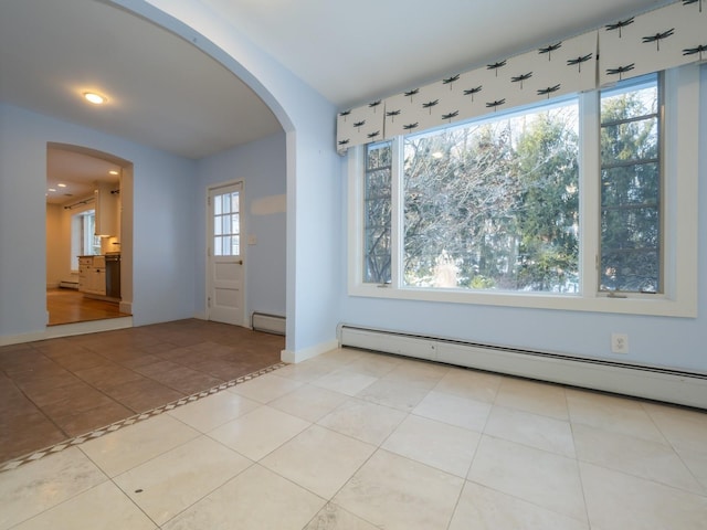 entrance foyer with baseboard heating, baseboards, arched walkways, and a baseboard radiator