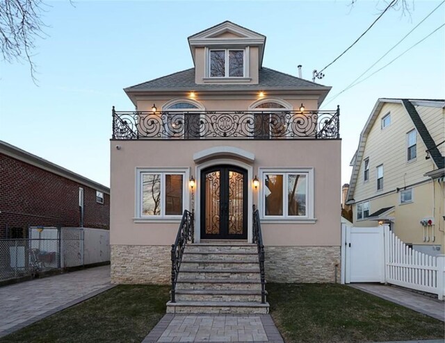 154-33 11th Ave, Whitestone, NY 11357 - view of front of property featuring stucco siding, fence, a gate, french doors, and a balcony