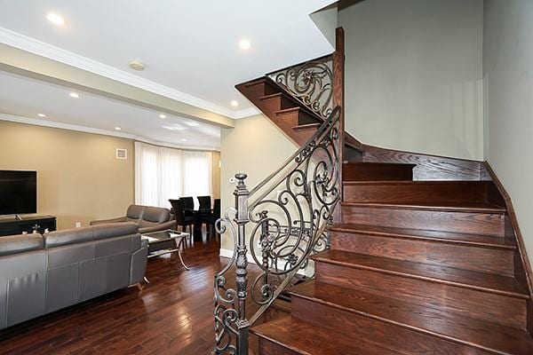 staircase featuring hardwood / wood-style flooring and ornamental molding