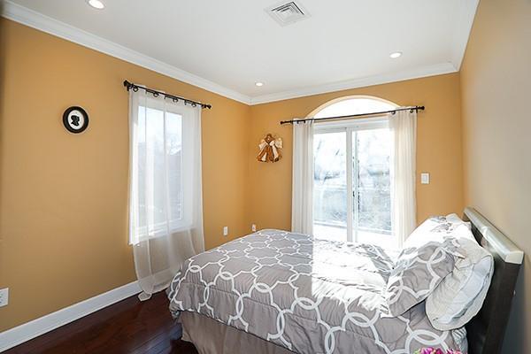 bedroom with crown molding and dark hardwood / wood-style flooring