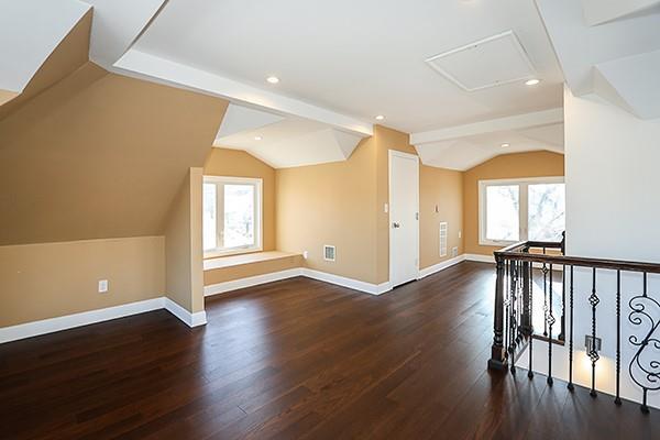 bonus room with a healthy amount of sunlight, dark hardwood / wood-style floors, and lofted ceiling