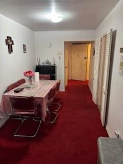 dining room featuring dark colored carpet