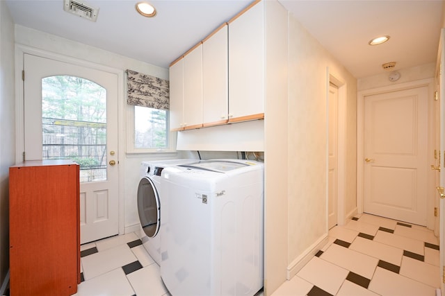 washroom with washer and dryer and cabinets