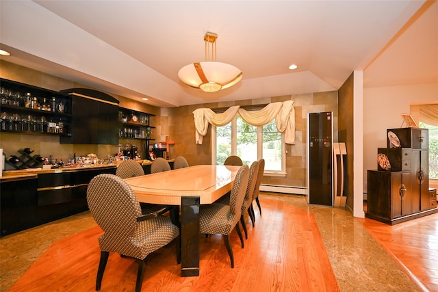 dining room with bar, light hardwood / wood-style flooring, and baseboard heating