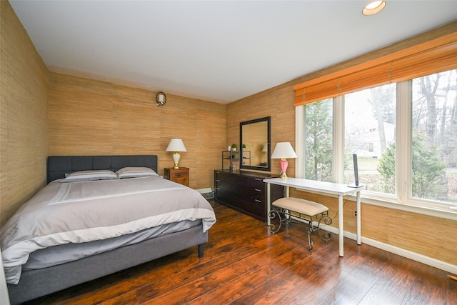 bedroom with dark hardwood / wood-style flooring and multiple windows