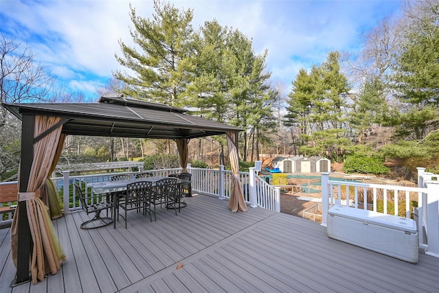 wooden deck with a gazebo and a storage shed