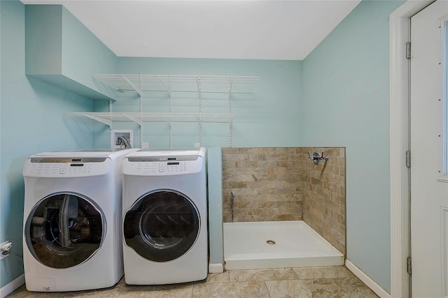 clothes washing area with washer and dryer and light tile patterned flooring