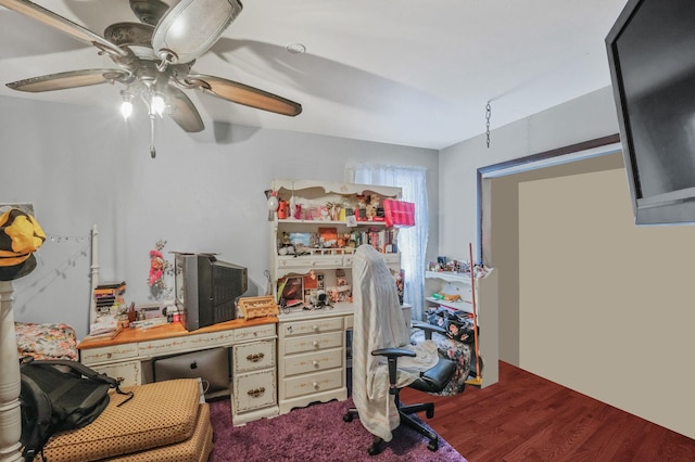 home office with dark wood-type flooring and ceiling fan