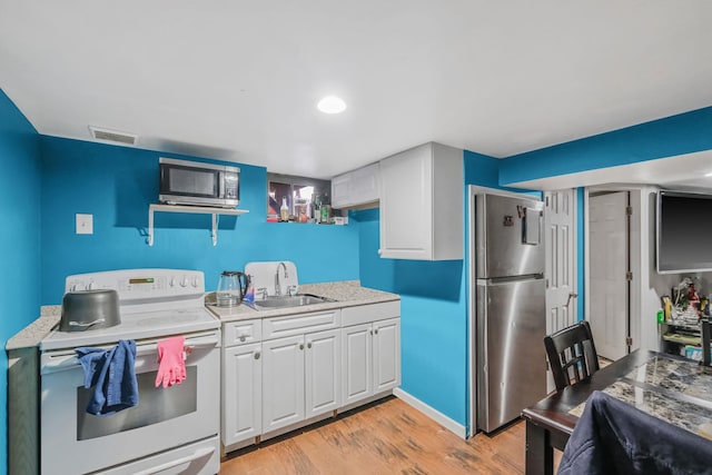 kitchen with white cabinetry, sink, light hardwood / wood-style flooring, and stainless steel appliances