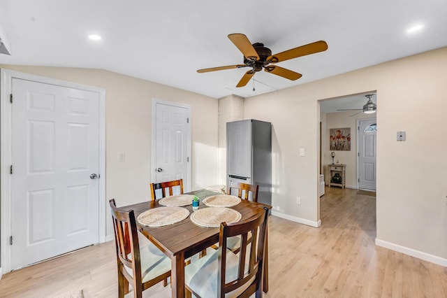 dining area with ceiling fan, lofted ceiling, and light hardwood / wood-style flooring