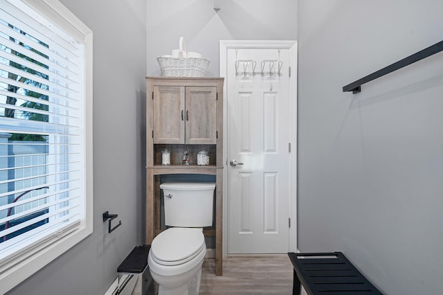 bathroom with tasteful backsplash, toilet, and hardwood / wood-style flooring